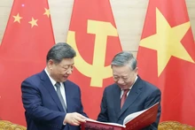 El secretario general del Partido Comunista de Vietnam, To Lam, entrega respetuosamente al secretario general del Partido Comunista y presidente de China, Xi Jinping, un libro de fotografías de la Agencia de Noticias de Vietnam, que incluye fotos típicas e impresionantes de las cinco visitas de Xi Jinping al país indochino. (Foto: VNA)