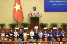 El presidente de la Asamblea Nacional, Vuong Dinh Hue, entrega obsequios a destacados miembros sindicales y trabajadores desfavorecidos. (Foto: VNA)