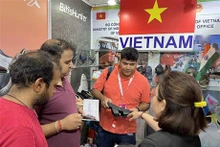 Visitantes visitan pabellones de calzado vietnamita en la feria. (Foto: VNA)