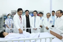 El presidente Vo Van Thuong (cuarta persona desde la izquierda) visita a un paciente que recibe tratamiento en el Hospital de Pediatría 1 de Ciudad Ho Chi Minh. (Fotografía: VNA)