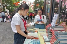 Los estudiantes leen libros en la calle de los libros de Hanói. (Foto: VNA)