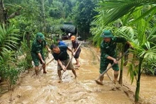 Los oficiales y soldados de guardia fronteriza ayudan a las personas a superar las consecuencias de las inundaciones. (Fotografía: VNA)