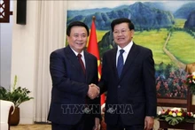 Nguyen Xuan Thang (izquieda), miembro del Buró Político y director de la Academia Nacional de Política Ho Chi Minh, y el secretario general del Partido Popular Revolucionario y presidente de Laos, Thongloun Sisoulith. (Fotografía: VNA)