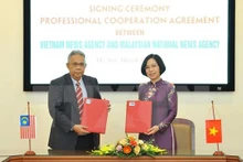 Directora general de VNA, Vu Viet Trang, y el editor en jefe de BERNAMA, Khairdzir bin Md Yunus, firmaron un acuerdo de cooperación profesional. (Foto: VNA)