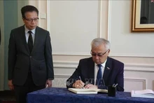 Bair Zhamsuyev, vicepresidente del Comité de Asuntos Exteriores del Consejo de la Federación de la Asamblea Federal de Rusia, escribe en el libro de condolencias durante la ceremonia celebrada por la Embajada de Vietnam en Rusia. (Foto: VNA)