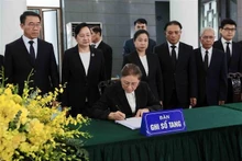 La vicepresidenta de Laos, Pany Yathotou, escribe en el libro de condolencias del expresidente Tran Duc Luong. (Foto: VNA)