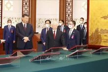 El secretario general del PCV, Nguyen Phu Trong, y el secretario general del PCCh y presidente de China, Xi Jinping, aprecian los documentos de cooperación firmados. (Fotografía: VNA)
