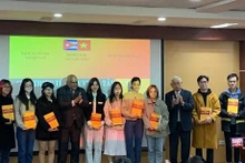 El autor Vu Van Au y el embajador de Cuba en Vietnam, Orlando Nicolás Hernández Guillén, presentan el diccionario vietnamita-español a estudiantes del Departamento de Español de la Universidad de Hanói (Fotografía: nhandan.vn)