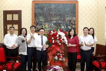La ministra de Salud Pública, Dao Hong Lan, entrega flores para felicitar al periódico Nhan Dan.