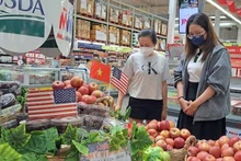 Los consumidores eligen manzanas estadounidenses en un supermercado de Ciudad Ho Chi Minh. (Foto: nld.com.vn)