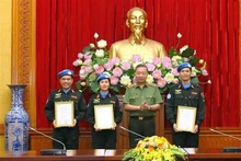 El ministro de Seguridad Pública, general To Lam, entrega la decisión del Presidente de Vietnam a los oficiales. (Fotografía: VNA)
