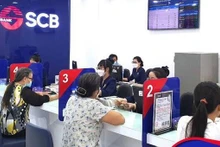 Clientes realizan transacciones en el banco SCB. (Fotografía: VNA)