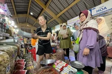 Turistas musulmanes visitan y compran especialidades vietnamitas en el mercado Ben Thanh, en Ciudad Ho Chi Minh. (Foto: sggp.org.vn)