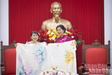 Ngo Phuong Ly, esposa del secretario general del Partido Comunista de Vietnam, To Lam, entrega a la del primer ministro japonés, Ishiba Yoshiko, un pañuelo de seda estampado con flores de loto y crisantemo. (Foto: Nhan Dan)