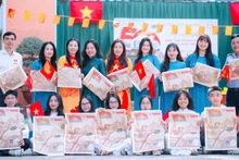 Docentes y estudiantes en Dong Nai con el suplemento especial del periódico Nhan Dan.