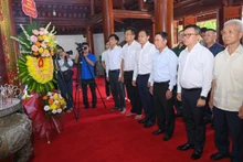 Los delegados ofrecen flores para rendir tributo al Presidente Ho Chi Minh en su casa conmemorativa en el Cementerio Internacional de Mártires de Vietnam-Laos. 
