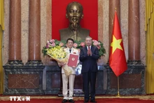 El secretario general del Partido Comunista y presidente de Vietnam, To Lam, entrega la decisión de promoción al rango de general a Luong Tam Quang, ministro de Seguridad Pública. (Foto: VNA)