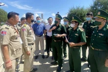 Oficiales y soldados de la estación de guardia fronteriza de la puerta fronteriza internacional de Tinh Bien, de la provincia vietnamita de An Giang intercambian procedimientos legales antes de recibir a 26 ciudadanos vietnamitas entregados por Camboya. (Fotografía: VNA)