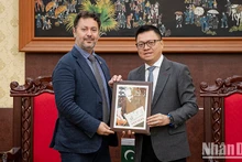 Le Quoc Minh, presidente-editor del periódico Nhan Dan, entrega un regalo a Kohdayar Marri, embajador de Pakistán en Vietnam.