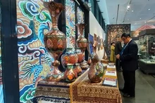 Unos visitantes contemplan el arte persa en la exposición. (Foto: es.dangcongsan.vn)