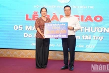 El presidente-editor de Nhan Dan, Le Quoc Minh, entrega un simbólicamente el apoyo a la Unión de Mujeres de la provincia de Ben Tre.