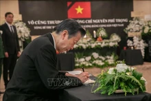 Presidente del Partido Nuevo Kōmeitō de la coalición gobernante de Japón, Natsuo Yamaguchi, escribe en el libro de condolencias. (Foto: VNA)