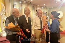Bernard Bachelard y Olivier Parriaux con jóvenes de Ciudad Ho Chi Minh. (Foto: VNA)