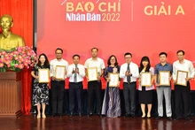 El presidente-editor del periódico Nhan Dan, Le Quoc Minh, y subredactor jefe Dinh Nhu Hoan entregan el premio A a los autores y representantes de grupos de autores. 