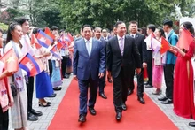 El primer ministro de Camboya, Samdech Moha Bovor Thipadei Hun Manet, y el premier anfitrión, Pham Minh Chinh, sostienen un intercambio con maestros y estudiantes de la Universidad de Comercio Exterior de Vietnam.(Foto: VNA)