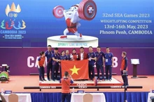 La halterófila Dinh Thi Thu Uyen (medio) celebra su victoria (Fotografía: VNA)