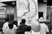 Los habitantes del municipio de Phan Thiet, provincia de Binh Thuan, recién liberada, siguen la noticia de la victoria en la oficina de información de la localidad (abril de 1975). (Foto: Mai Huong/VNA)