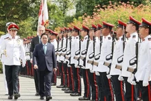 El primer ministro vietnamita, Pham Minh Chinh, y su homólogo singapurense, Lee Hsien Loong, en la ceremonia de recepción oficial (Fotografía: VNA)