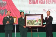 El presidente Vo Van Thuong (derecha) presenta un retrato del Presidente Ho Chi Minh al Alto Mando de la Guardia Fronteriza. (Foto: VNA)