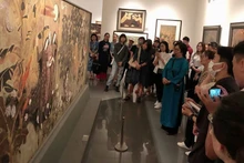 Los turistas conocen las obras durante el recorrido sobre pintura de laca en el Museo de Bellas Artes de Vietnam (Foto: VNA)