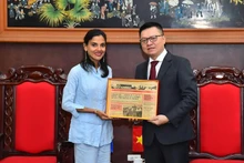 El presidente-editor del periódico Nhan Dan recibe un regalo de recuerdo entregado por Arlin Alberty Loforte, subdirectora del diario Granma. 