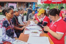 Los pobladores de la minoría étnca de Co Tu configuran sus nuevos celulares (Foto: VNA)