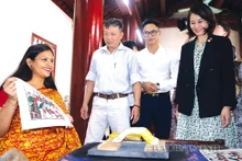 Turistas extranjeros aprenden sobre las pinturas de Dong Ho (Fotografía: baobacninh.vn)