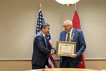 El vicepresidente y secretario general de la Unión de Organizaciones de Amistad de Vietnam, Phan Anh Son, entrega el sello conmemorativo “Por la paz y la amistad entre los pueblos” a Ron Carver, activista social estadounidense por la paz. (Fotografía: VNA)