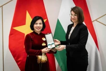 La secretaria de Estado de Relaciones Bilaterales del Ministerio de Asuntos Exteriores y Comercio Exterior de Hungría, Illés Boglárka, entrega la Cruz de la categoría de Oficial de la Orden del Mérito a la embajadora vietnamita en Budapest, Nguyen Thi Bich Thao. (Foto: VNA)
