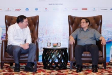 El primer ministro de Vietnam, Pham Minh Chinh (derecha), conversa con Thammasak Sethaudom, presidente y director ejecutivo del grupo tailandés SCG. (Foto: VGP)