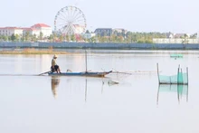 Un residente del distrito de Vi Thuy pesca en campos inundados.