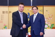 El primer ministro de Vietnam, Pham Minh Chinh y Cao Ronggen, presidente del Centro Internacional de Subastas de Flora de Kunming (KIFA) (Foto: VNA)