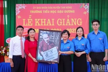 El periódico Nhan Dan entrega a la escuela primaria Dau Duong un obsequio de recuerdo.