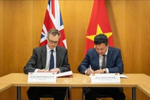 El coronel Vu Van Hung (derecha) y el ministro de Lucha contra la Migración Ilegal del Reino Unido, Michael Tomlinson, firman en Londres la Declaración Conjunta sobre cooperación para prevenir la migración ilegal. (Foto: Ministerio del Interior británico)