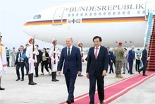 El canciller alemán Olaf Scholz (I) es recibido en el Aeropuerto Internacional Noi Bai en Hanói. (Fotografía: VNA)