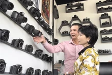 A visitor learns about the cameras on display at Like Coffee and Tea on Le Hong Phong Street, Nga Bay City, Hau Giang Province, southern Vietnam. (Foto: Tuoitre.vn)