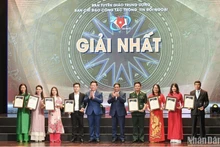 El primer ministro vietnamita, Pham Minh Chinh, y el jefe de la Comisión de Comunicación y Educación del Partido y del Comité Directivo del Servicio de Información al Exterior, entregan el primer premio a los autores. (Foto: Thanh Dat)