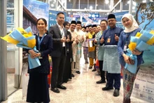Representantes de Vietnam Airlines, Departamento General de Turismo de Malasia y el Aeropuerto Internacional de Kuala Lumpur esperan para recibir a los primeros pasajeros del vuelo Hanoi-Kuala Lumpur en la noche del 1 de abril de 2025. (Foto: VNA)