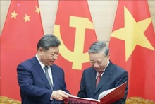 El secretario general To Lam regala al secretario general y presidente Xi Jinping el libro fotográfico de la Agencia Vietnamita de Noticias. (Foto: VNA)