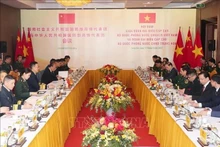 El ministro de Defensa de Vietnam, general Phan Van Giang, dialoga con su homólogo chino, general Dong Jun. (Foto: VNA)